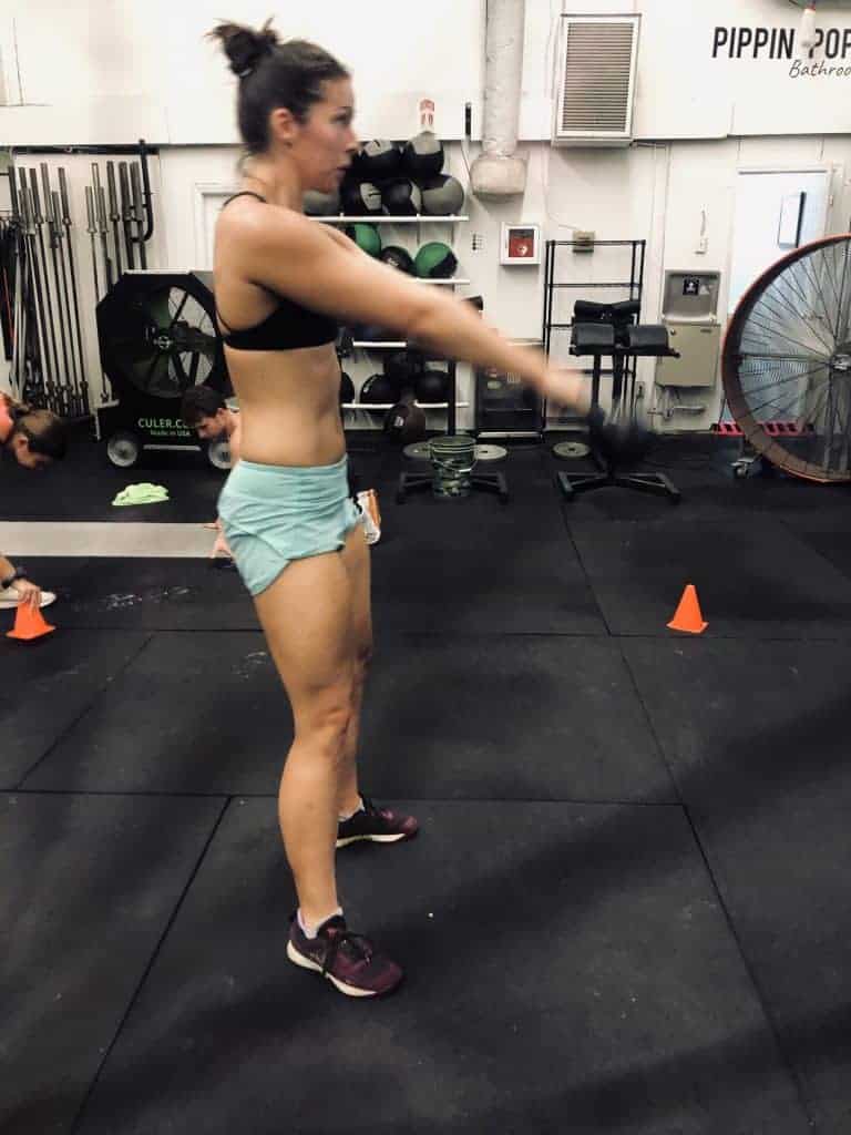 Woman in gym doing a kettlebell swing