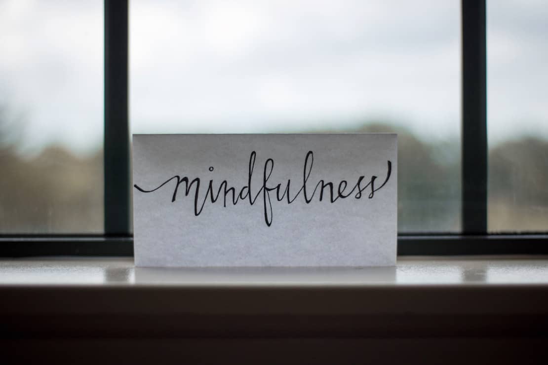 piece of paper that reads mindfulness in a window