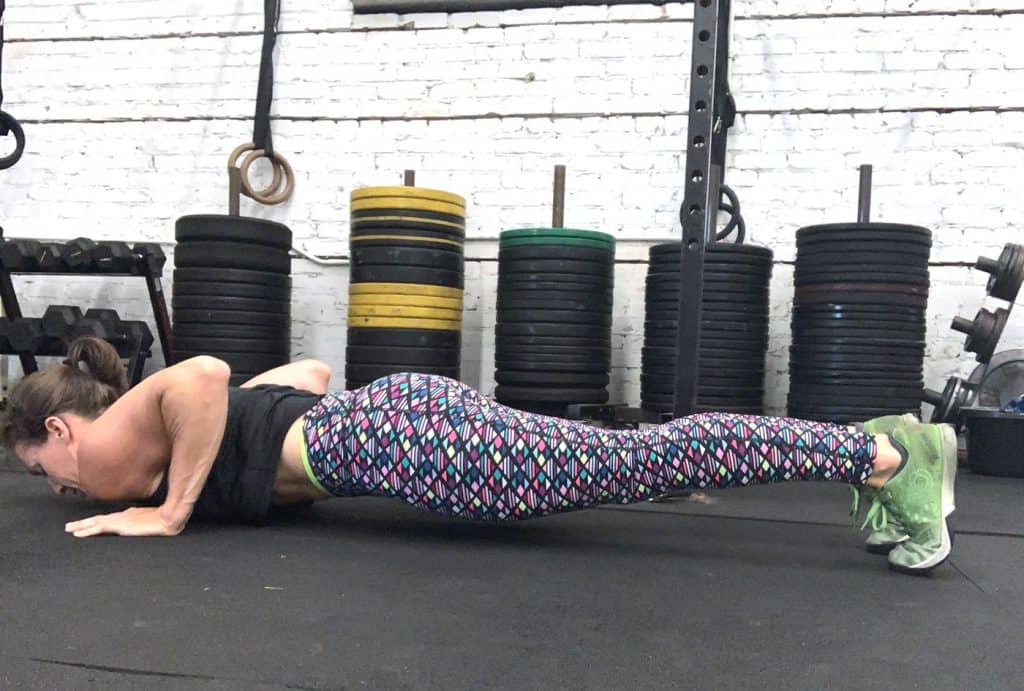 woman in a gym in the bottom of a push up